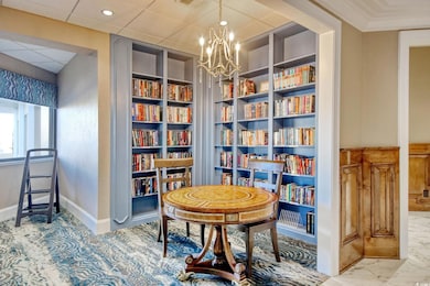 Sitting room featuring an inviting chandelier, crown molding, and built in features