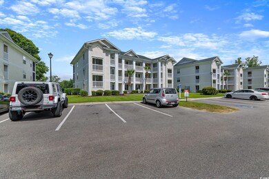View of apartment building / complex featuring uncovered parking