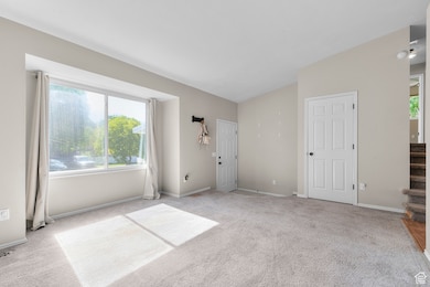 Unfurnished bedroom with light colored carpet and baseboards