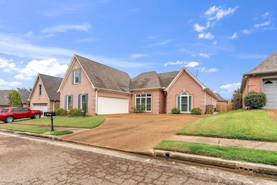 Traditional-style house featuring brick siding, a shingled roof, driveway, and a front yard