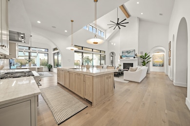 Upon entering you immediately see the quality construction and high end finishes with architectural detail everywhere you look. From vaulted ceilings with windows and transoms above each picture window to archways and ceiling details in each space. The white oak flooring stretches throughout the house and above the Perla Ventana extra thick countertops the Ralph Lauren Cara Sculpted pendant lights give a clean elegance to the space.