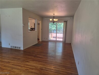 Traditional dining room with chandelier,  hardwood flooring and glass sliding doors to outdoor deck
