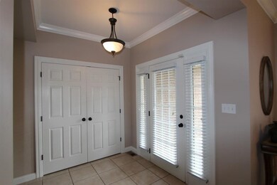 The foyer features a tile floor and crown molding.