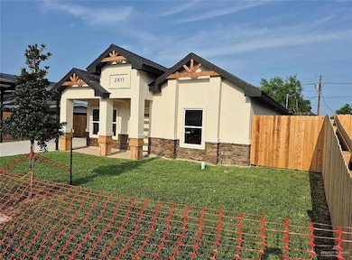 View of front of property featuring stucco siding, stone siding, and covered porch