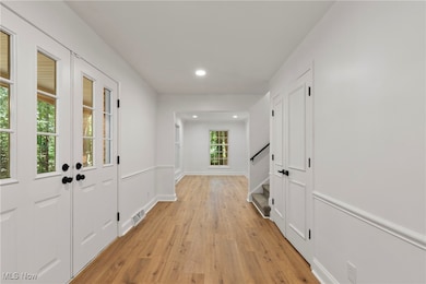 Corridor with light wood-style floors, stairs, and recessed lighting