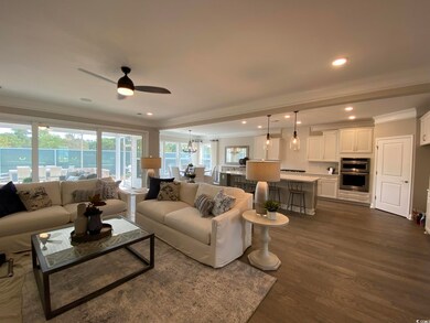 Living area featuring crown molding, dark wood finished floors, ceiling fan, and recessed lighting