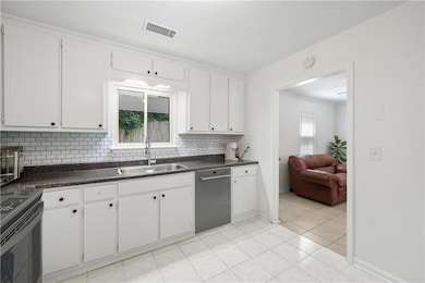 ***Virtually staged dishwasher***Kitchen featuring a sink, appliances with stainless steel finishes, backsplash, plenty of natural light, and ornamental molding