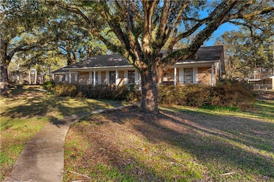 View of front facade with a front yard, a porch, and brick siding