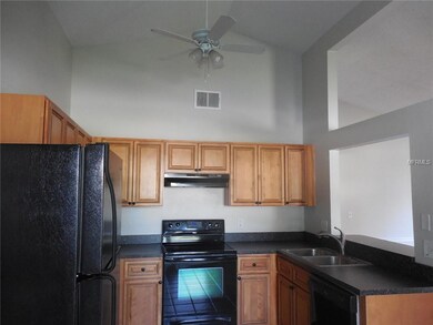 Kitchen has beautiful wood cabinets, smooth top range, stainless steel sinks and cathedral ceiling