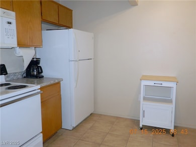 Kitchen featuring electric range, light countertop