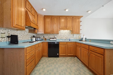 Kitchen with brown cabinetry, light countertops, d