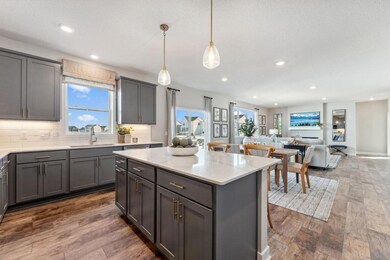 Open plan living, a window over the sink, and an abundance of storage. Photo of model home, colors and finishes are similar.