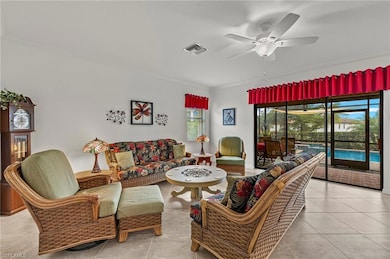 Tiled living room with ceiling fan, crown molding, views of the pool, spa and lake.