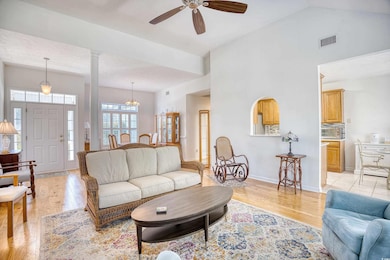Living area with high vaulted ceiling, light wood-
