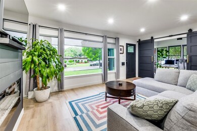 Living room featuring a barn door and light hardwo