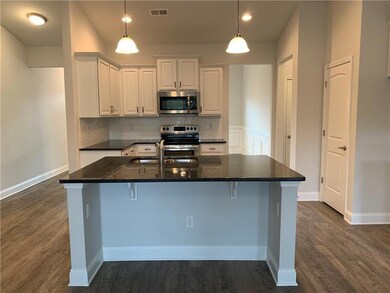 Kitchen with white cabinets, dark wood finished fl