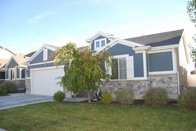 Craftsman inspired home featuring stone siding, a front lawn, driveway, and an attached garage