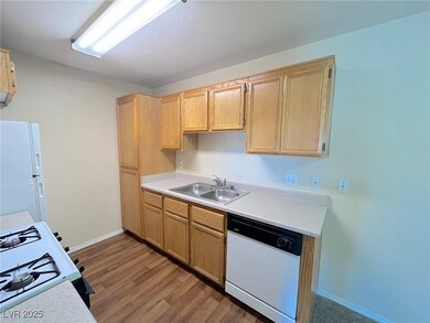 Kitchen with white appliances, light wood-style fl