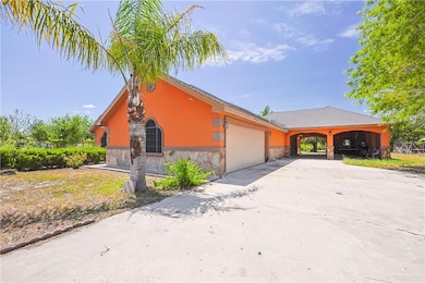 View of front of property featuring an attached garage, stone siding, and driveway