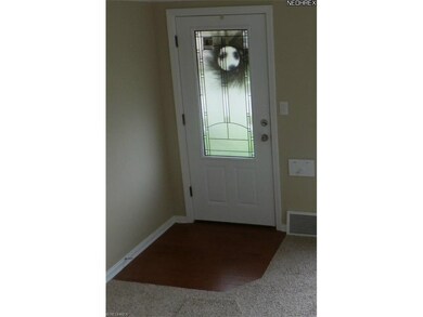 New front and rear exterior doors.  Pictured is the new hardwood floor at the front entrance.  Notice the new wall to wall carpeting.
