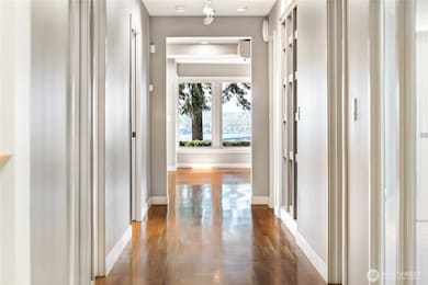 Rich hardwood floors guide you through the entry hallway, drawing the eye toward the expansive Lake Washington views that await beyond.