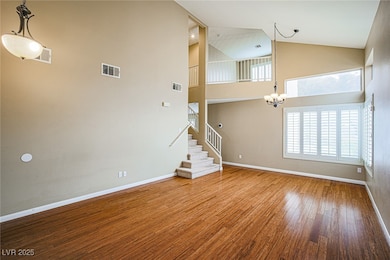 Unfurnished living room with a chandelier, high va