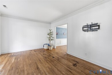 Spare room with ornamental molding and wood finished floors