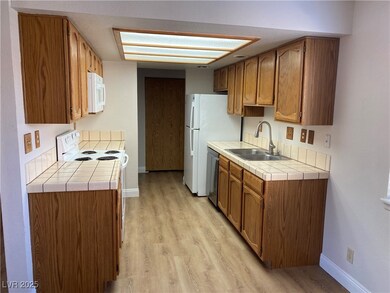 Kitchen featuring a sink, white microwave, baseboa