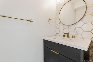 Bathroom featuring vanity and decorative backsplash.The pictures represent the model unit.The pictures represent the model unit.