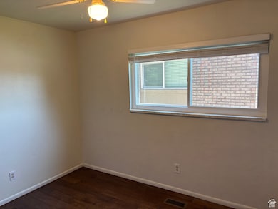 Spare room featuring plenty of natural light, ceiling fan, and wood finished floors
