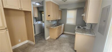 Kitchen with range with electric stovetop, washing