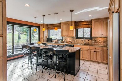 Many family memories to be made in the main gathering room of the home - the kitchen. Elegant renovation features huge granite island with bar seating and 6 burner gas grill.
