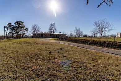 View of yard with driveway and fence