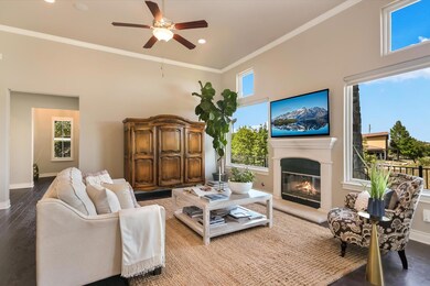 Living room featuring crown molding, a ceiling fa