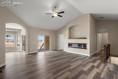 Living area with visible vents, baseboards, a glas