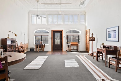 Carpeted entrance foyer with ceiling fan, ornament