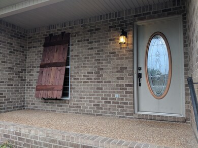 Front porch with custom cedar top shudder for privacy and new front door hardware.