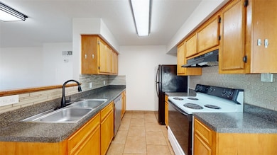 Kitchen featuring under cabinet range hood, dark c