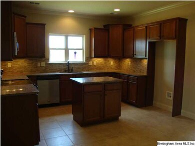 Gourmet kitchen with island, tile floor, under cab