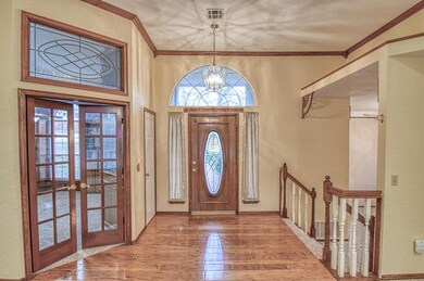 Entry French doors lead to Study and stairs down lead to formal dining room.