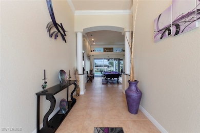Corridor featuring crown molding and light tile patterned floors