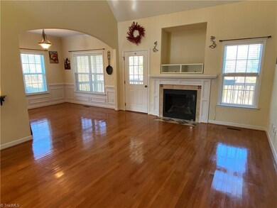 Den includes hardwoods, gas logs, and media shelf for TV above fireplace. To the left is the breakfast/eating area. Lots of natural light!