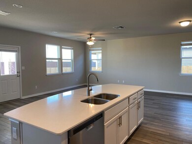 Kitchen featuring dishwasher, a sink, dark wood-t