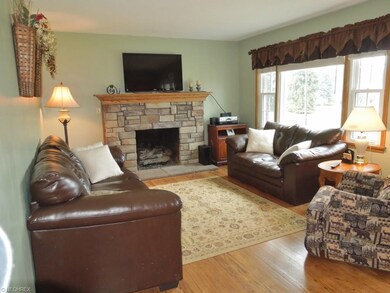 A different view of living room featuring stone fi