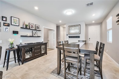 Dining room with light tile patterned floors and recessed lighting