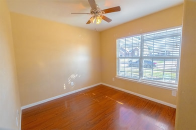 Spare room featuring wood finished floors and a ceiling fan