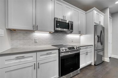 Kitchen featuring stainless steel appliances, dark