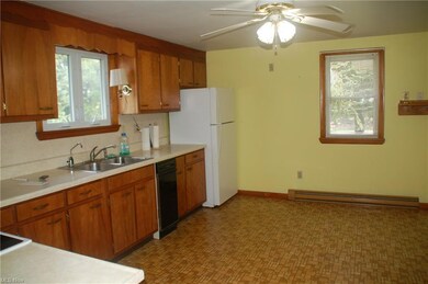 Kitchen featuring sink, tile flooring, ceiling fan, a baseboard radiator, and black dishwasher