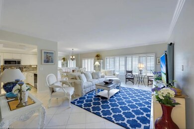 Living room with light tile patterned floors, ornamental molding, and a chandelier