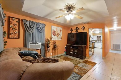 Tiled living room featuring ceiling fan and cooling unit